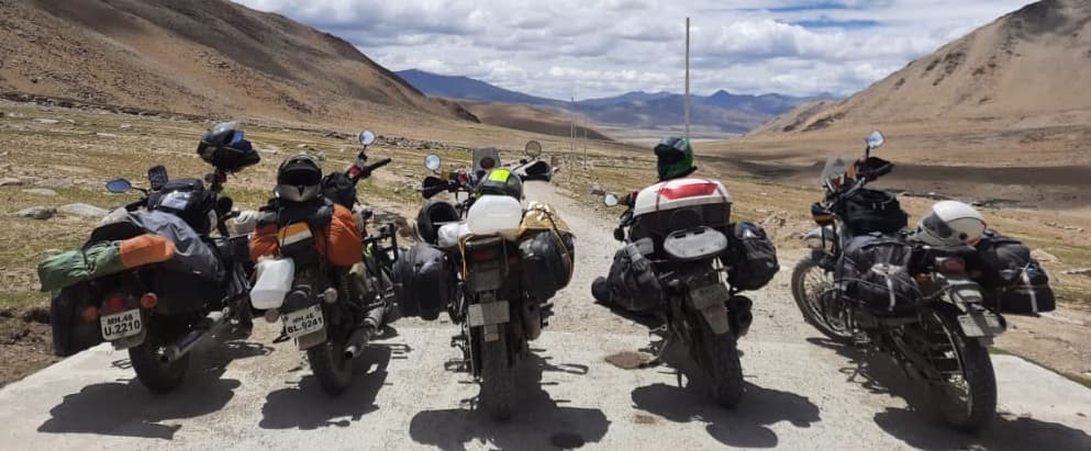 Riders gathered around motorcycles at a mountain campsite